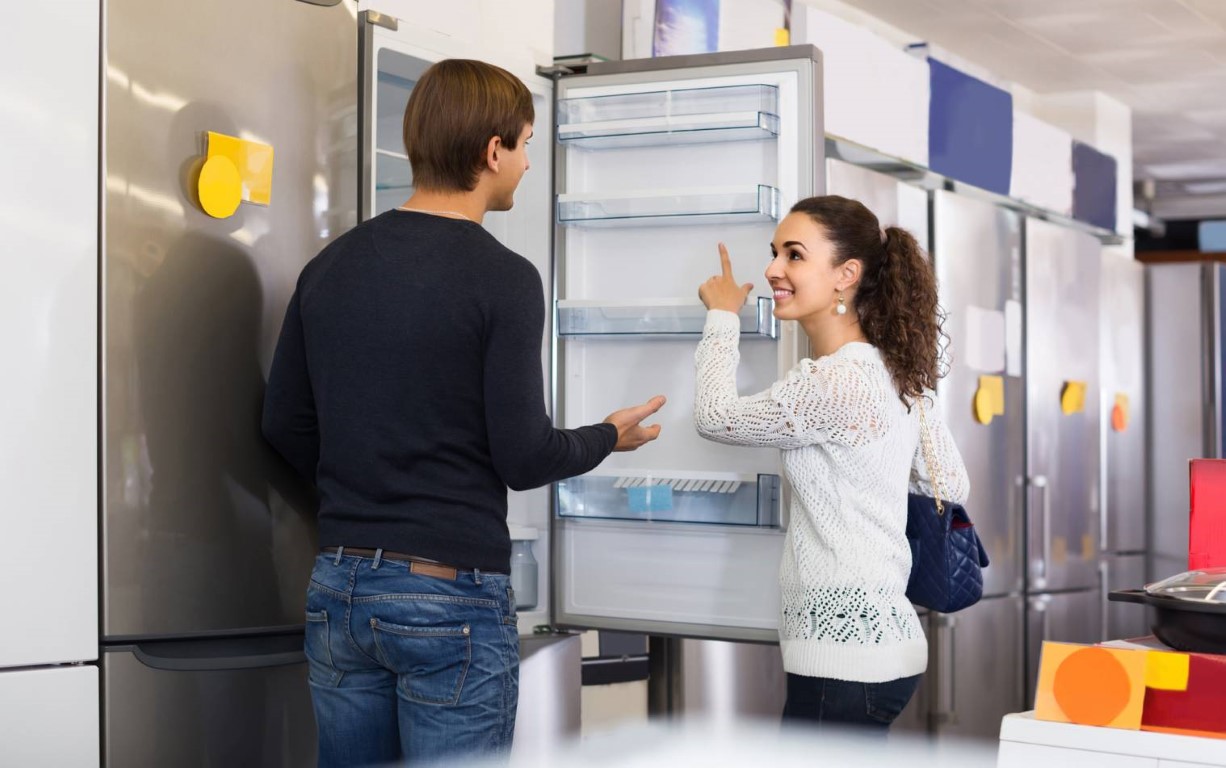 jeune couple qui choisit un frigo